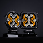 18W(1700Lm) LED darba lukturis KAMAR X-SPIDER 3 L0196 ar dzintarkrāsas LED joslu, 9 LED, 12/24V, IP67, alumīnija korpuss, 111x111x29,5mm, 0,3m kabelis, ECE R10, 2 gadu garantija